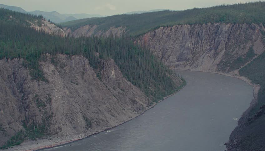 A river flows between two steep canyon walls