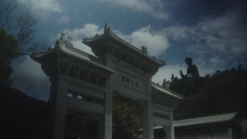 A chinese building gate wall standing in front of a traditional chinese building at midday