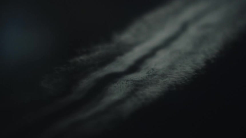 An ocean view at night with waves rhythmically crashing against the coastline