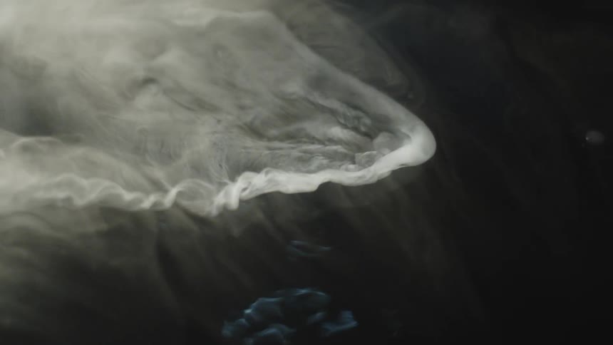 Swirl of white smoke dissipating over a dark background