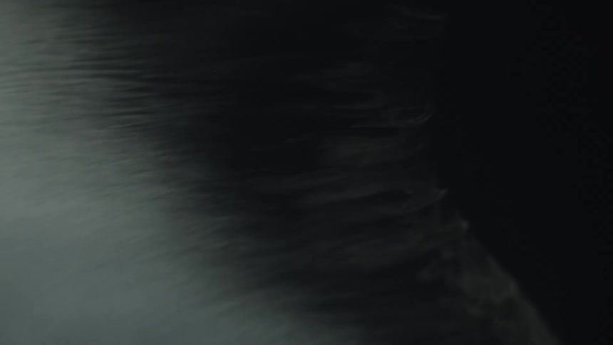 Rippled surface reflects light against dark background