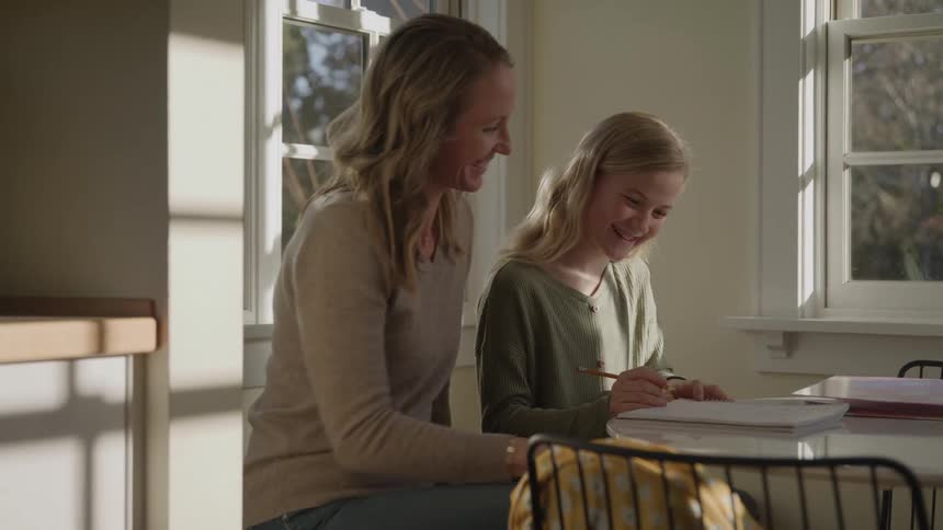 Mother helping her daughter do homework