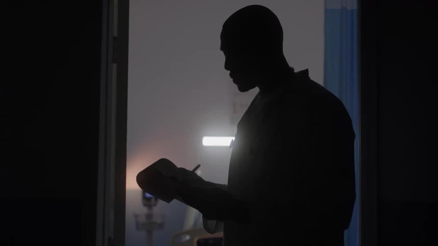 A man stands and writes