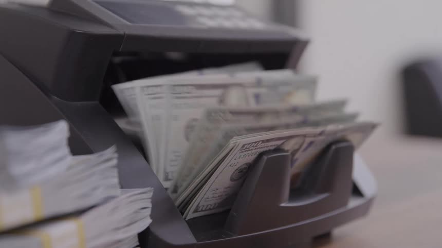 Money counting machine processing dollar bills at high speed