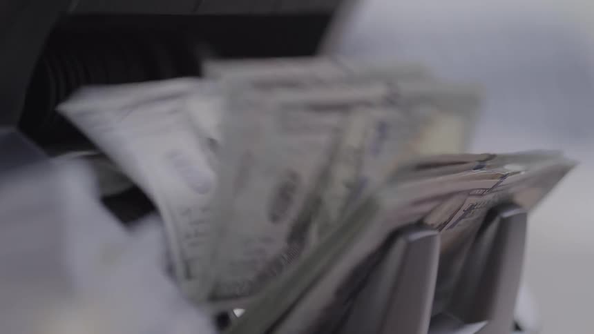 Dollar bills being rapidly processed by a counting machine