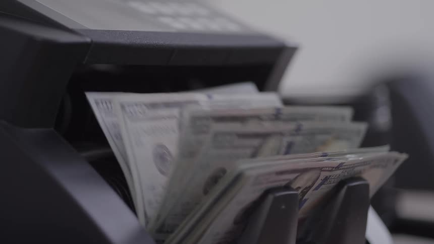 Dollar bills being rapidly counted in a machine