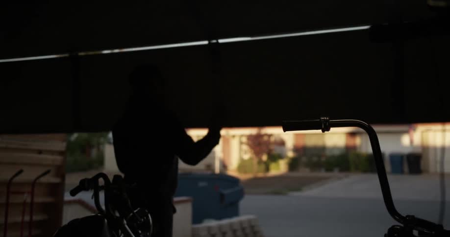 Man opens garage door on a neighborhood street