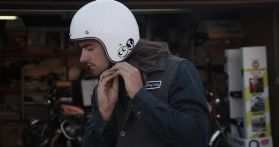 Man puts on helmet before getting onto motorcycle