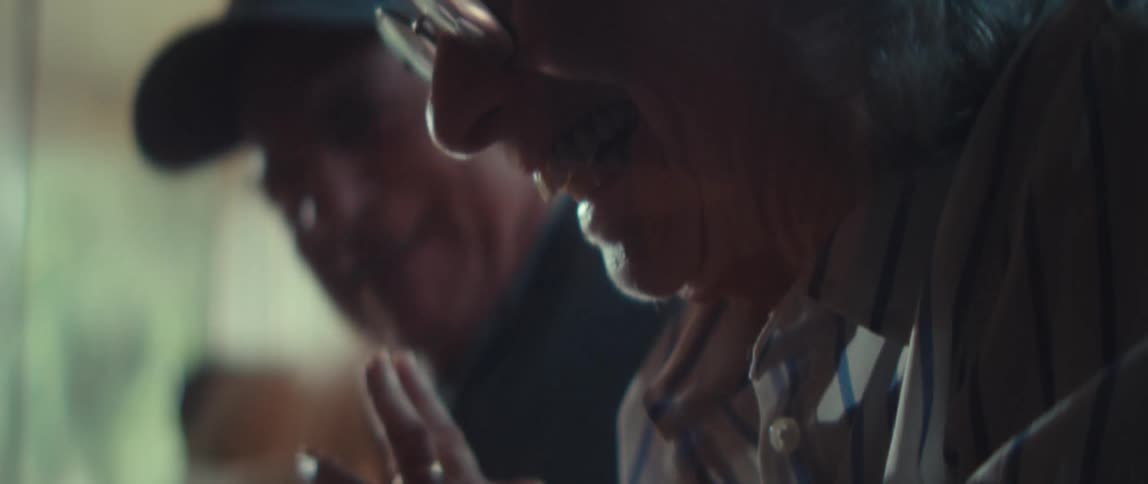 The man and woman begin laughing while putting together a jigsaw puzzle