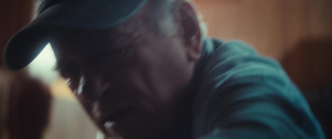 An elderly couple works together on solving a jigsaw puzzle at a table