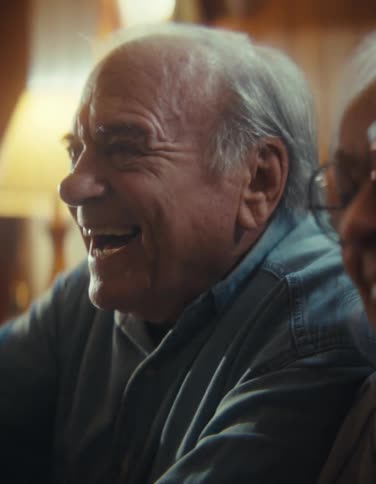 Elderly couple laughs together while holding video game controllers