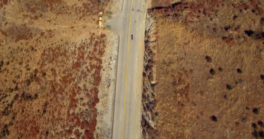 A motorcyclist rides on a rural road