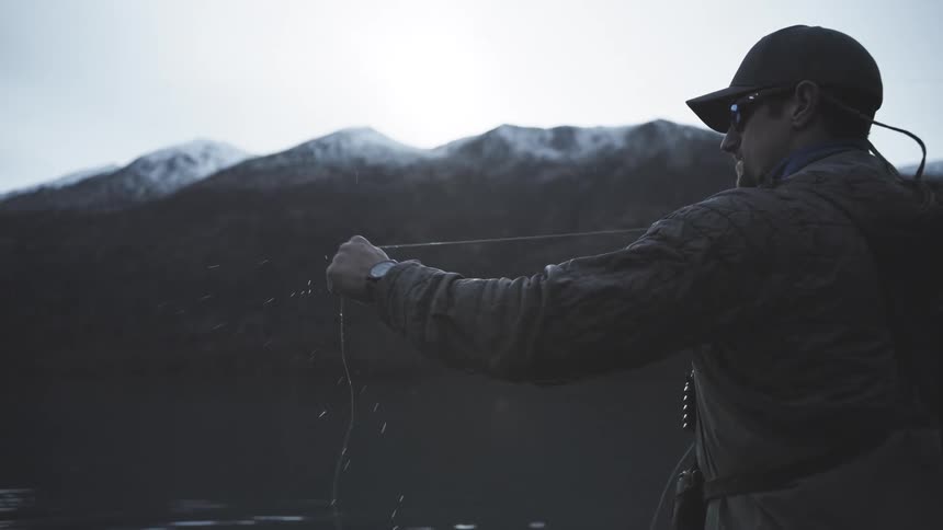 The man fly fishing swings the fishing pole back and forth