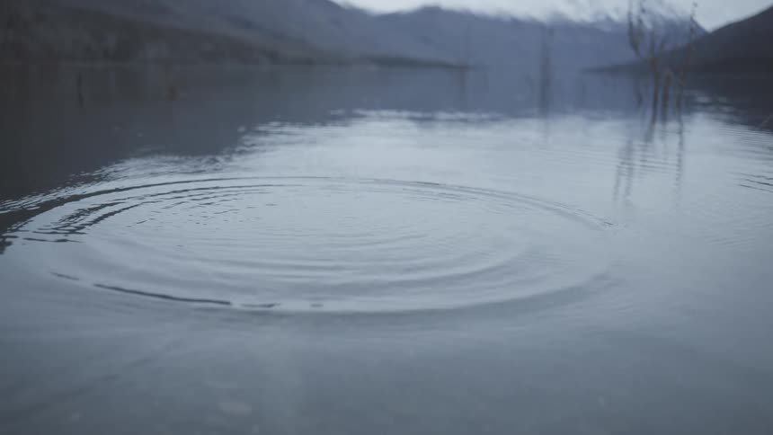 Slow motion of a fishing line cast into a lake causing ripples