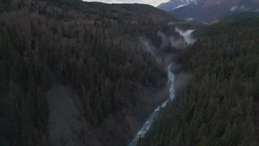An arial shot of a river running through a forest with rapids showing the speed of the river