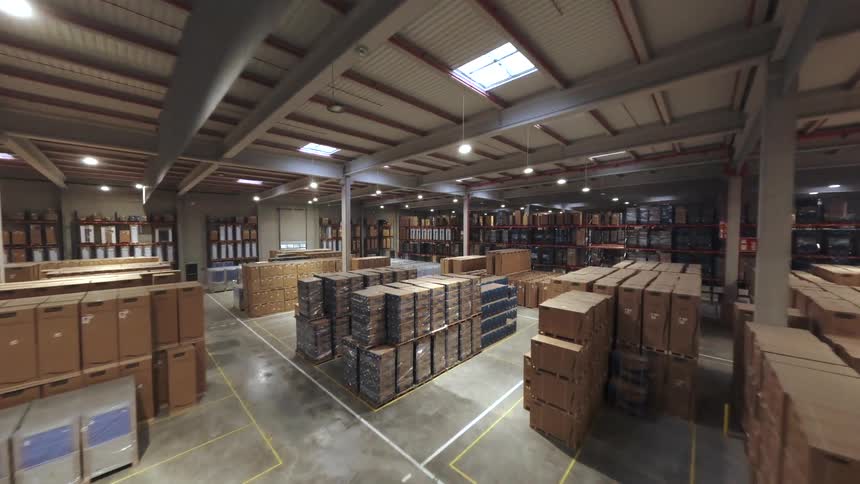 Spacious warehouse with numerous stacked boxes organized by sections