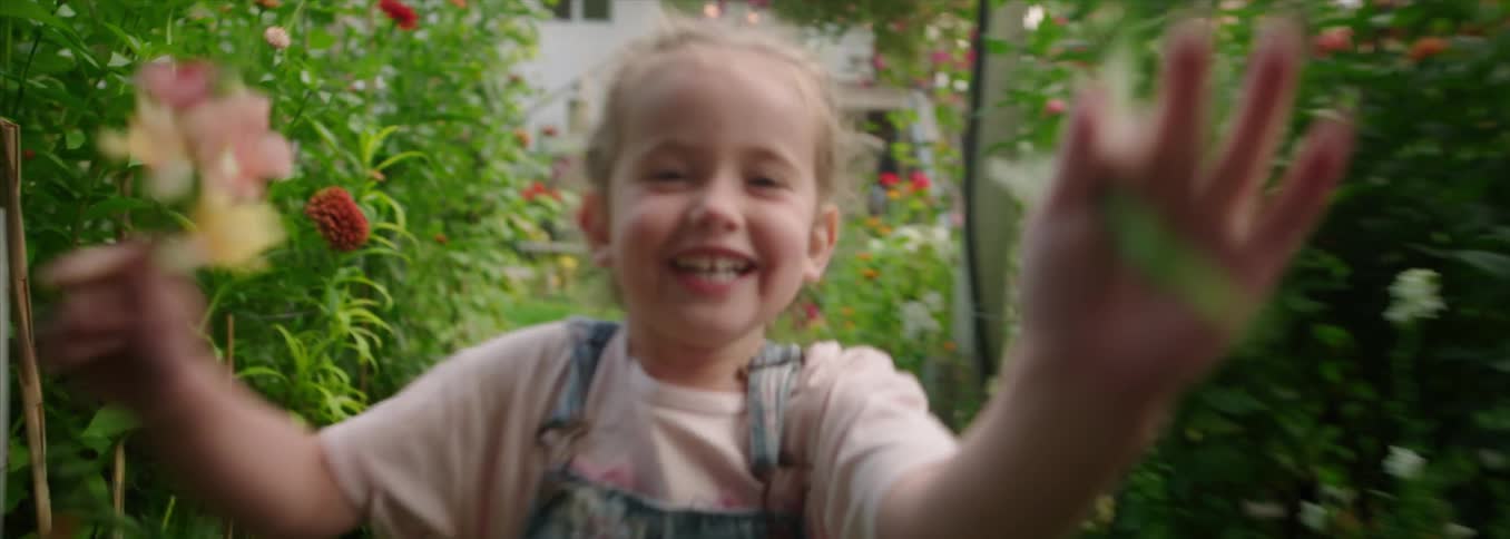 Child running joyfully along a flowerlined path