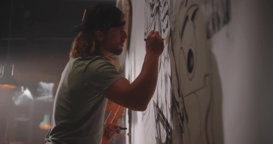 The man is drawing on the wall
