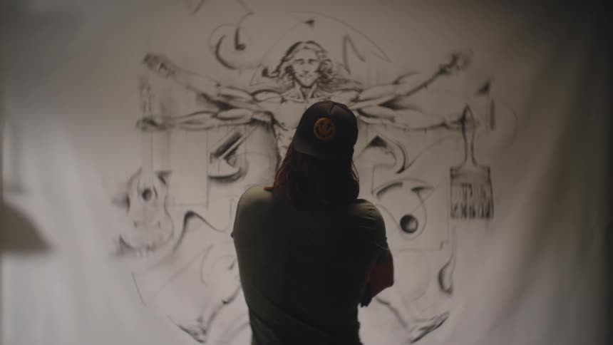 The artist is viewing drawing on the canvas