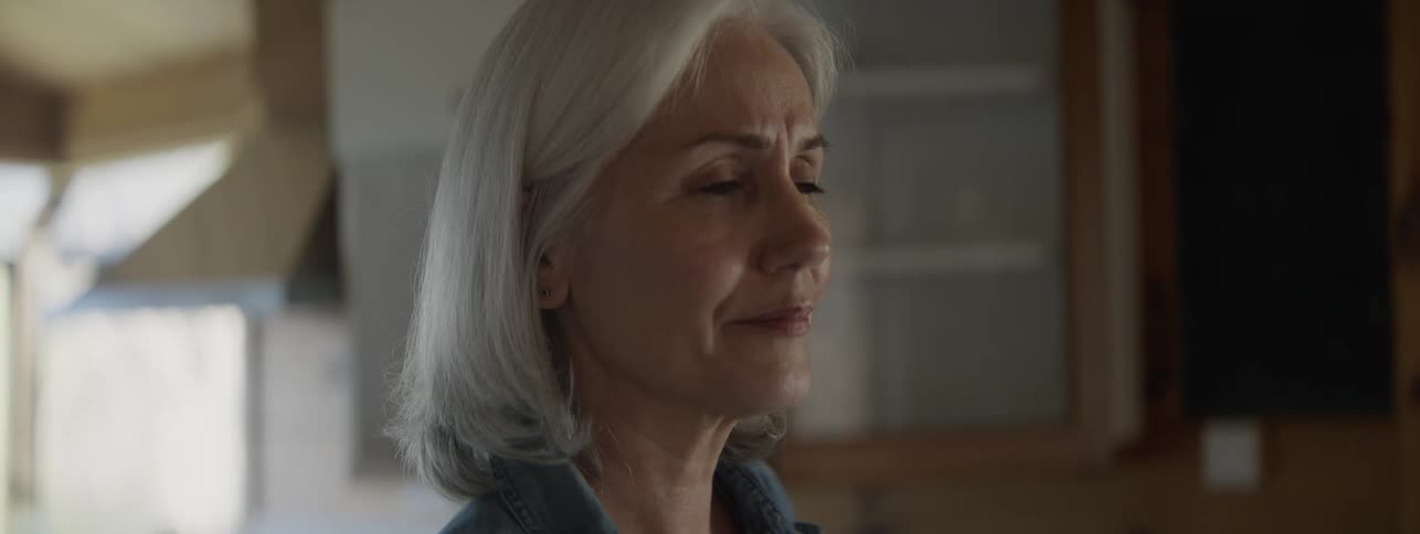 The realization of her husband developing dementia dawns on an older woman as tears well up in her eyes