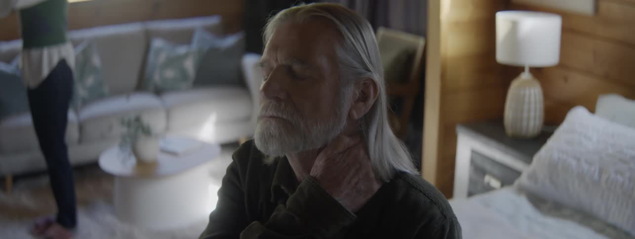 Grayhaired man sitting thoughtfully in a home setting