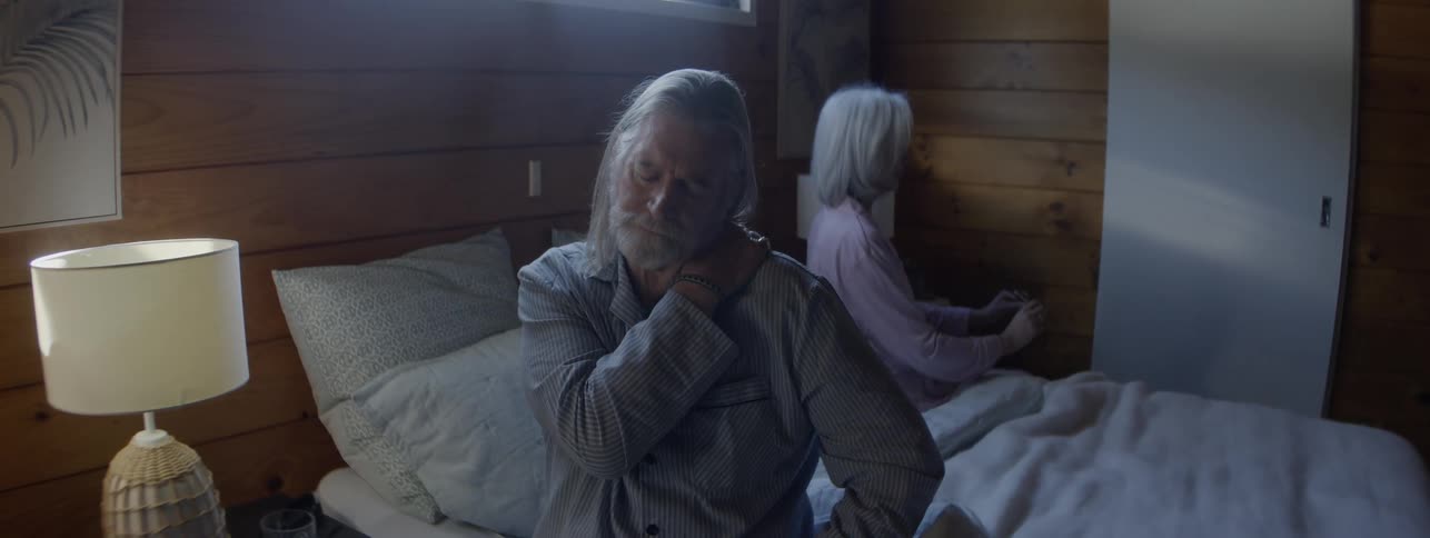 The man and woman sit in bed together