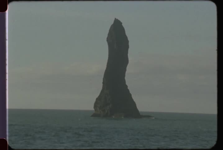 A tall rock formations stands in the ocean