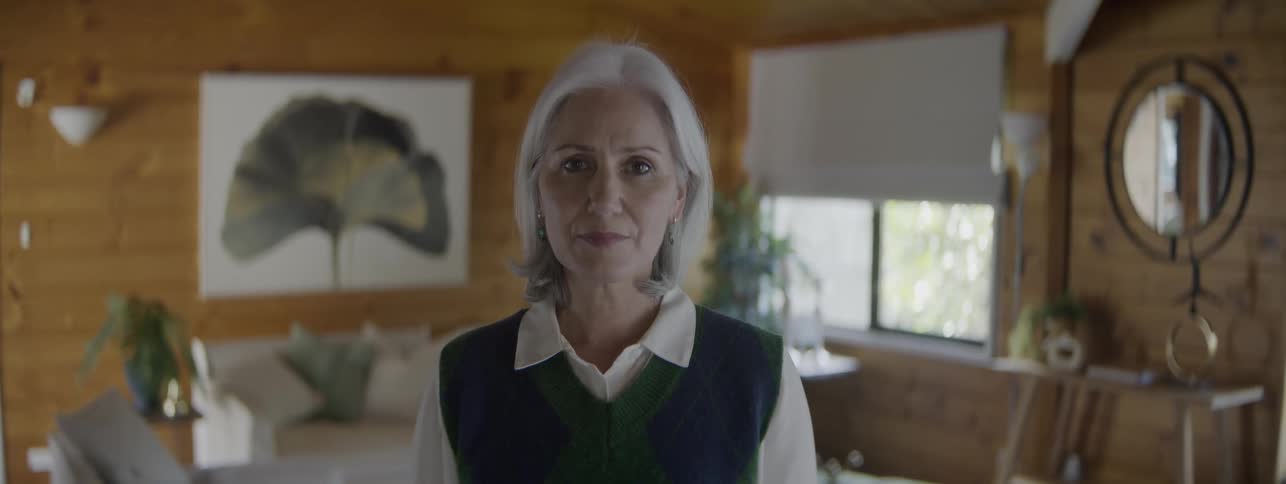 Grayhaired woman with a serene expression in a bright room