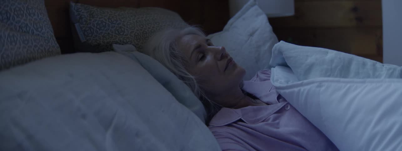 The woman gets up out of the bed