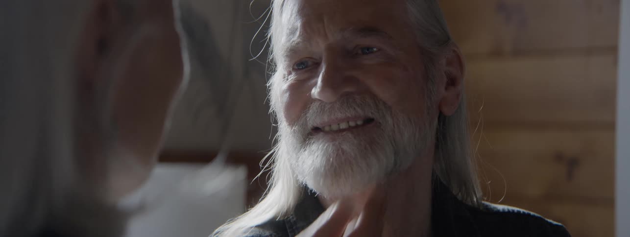 Close up portrait of an elderly man and woman conversing while together in a room during daytime