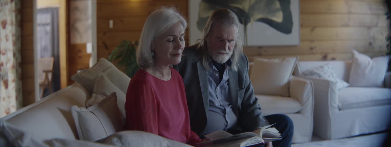 Elderly couple talking with a sad expression in a cozy living room
