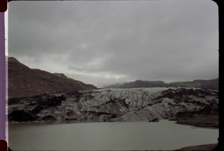 A pool of water leads to a mountain range