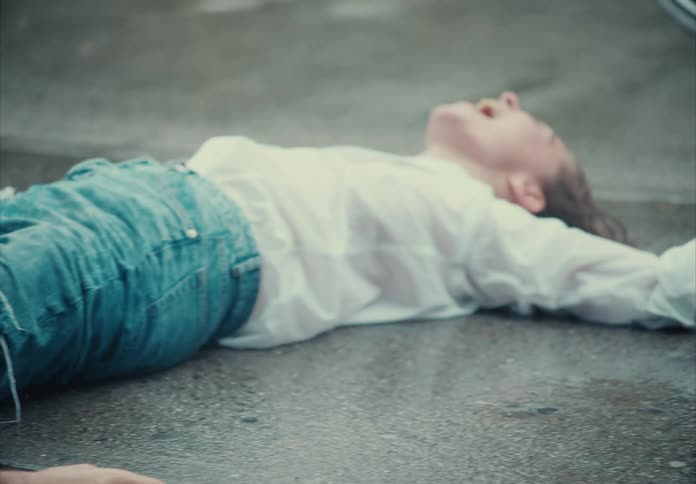 Friends enjoy lying on the sidewalk while it rains