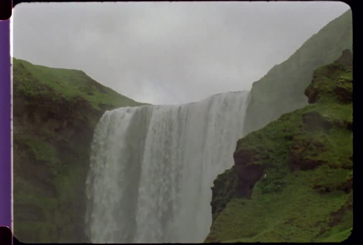 The waterfall is pouring off mist and water over the edge