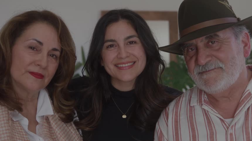 Close up of a mother and father with thier smiling adult daughter