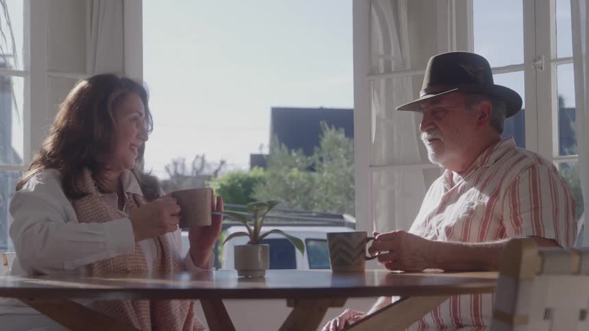 Mature couple chatting casually while having coffee at the table