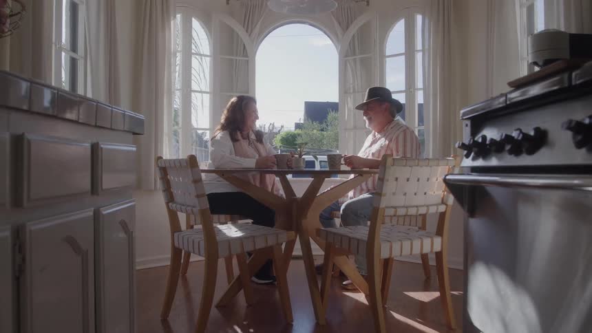 The couple sit by the window drinking coffee