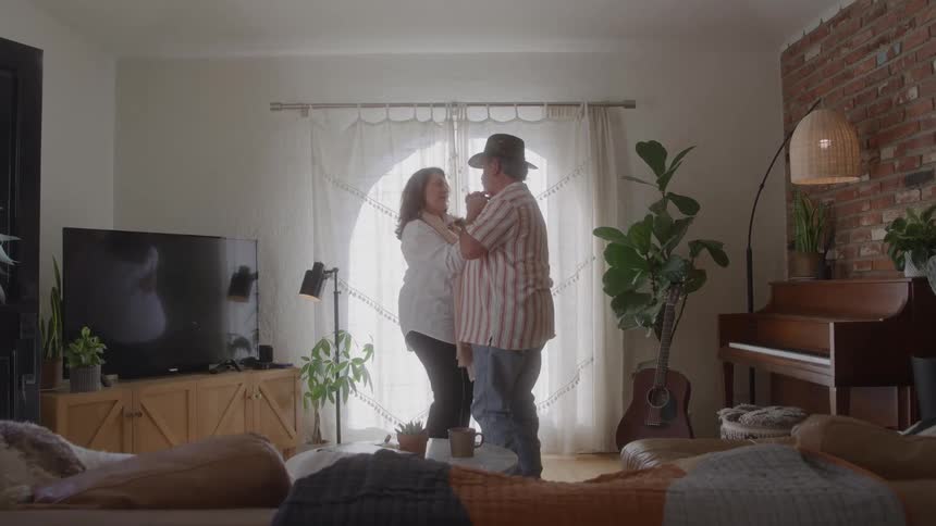 Couple dancing together in a bright and cozy living room