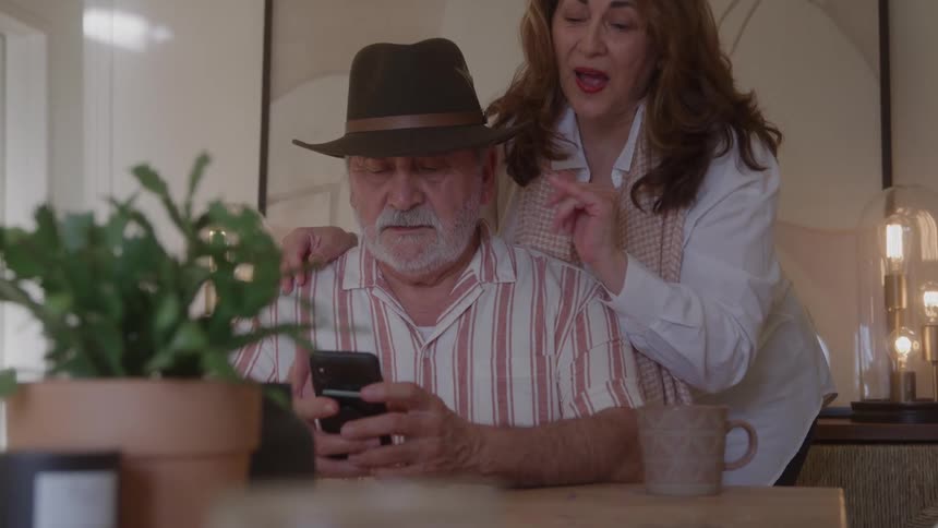 Older couple making a video call together at home
