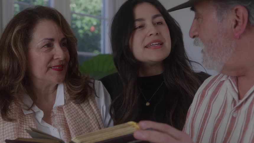 Three people talking while holding an open book