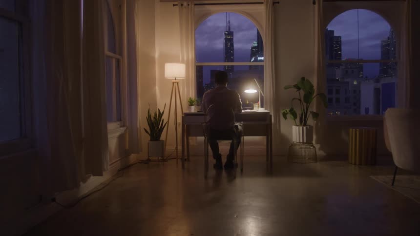A man sits at his desk at night
