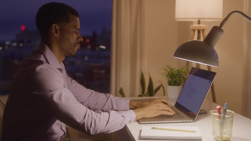A man types on his laptop