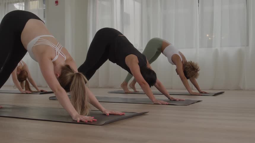 Practitioners perform downwardfacing dog pose during a yoga class