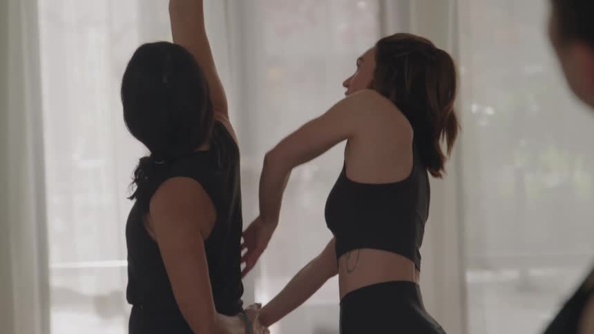 Instructor adjusts a students posture during a yoga practice