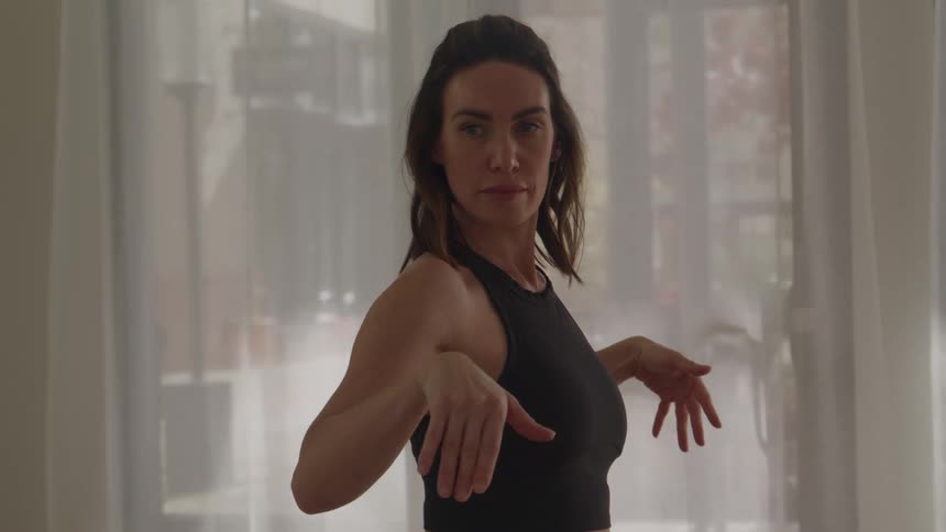 Woman extends her arms parallel to the floor during a yoga pose