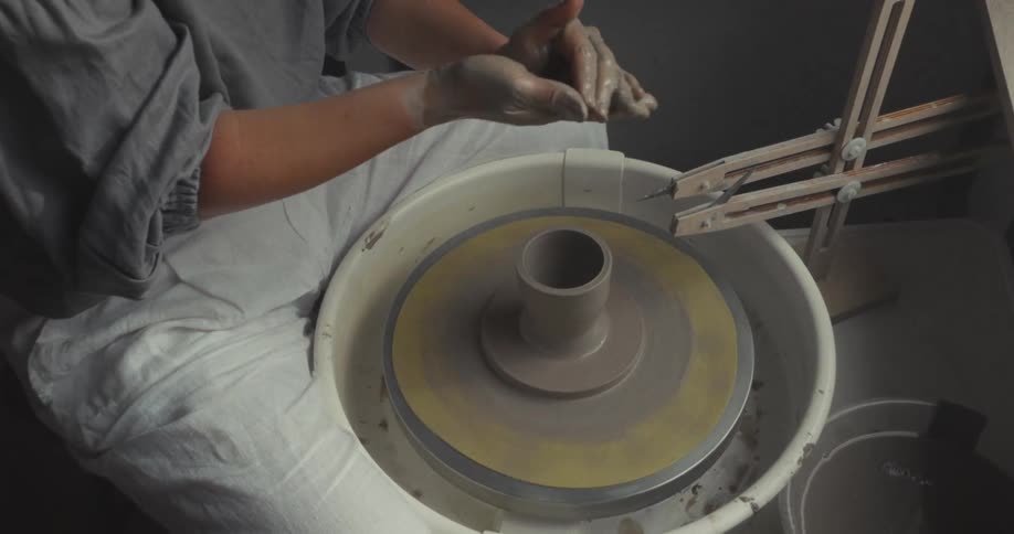 Woman shaping a ceramic piece on a pottery wheel