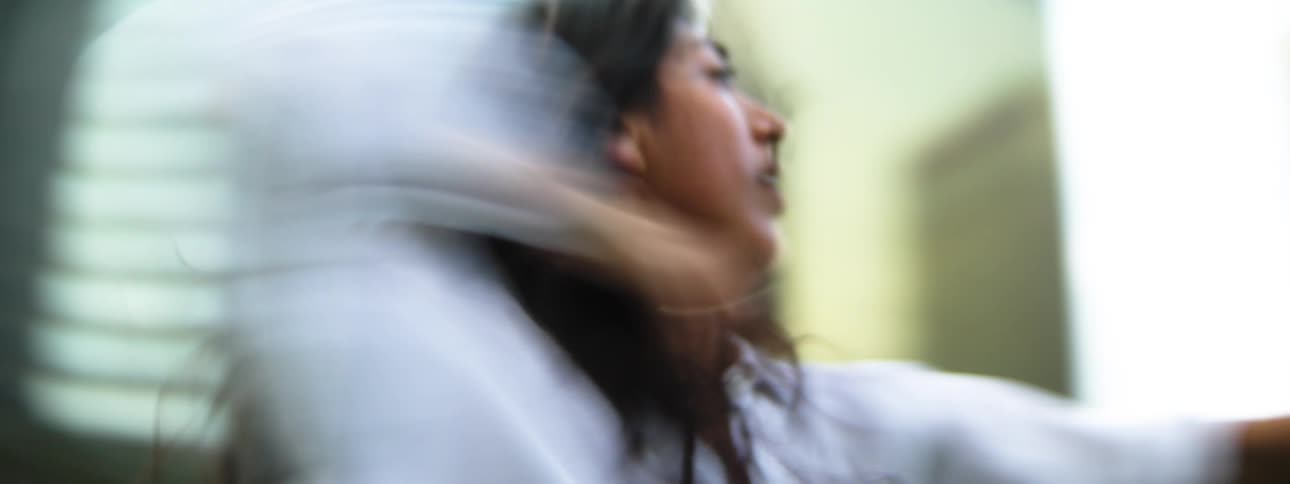 A young woman dancing outdoors in a metropolitan city during daytime