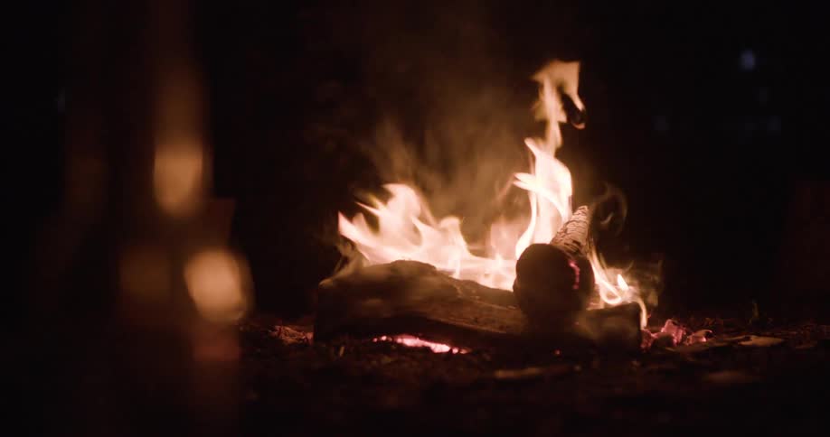 The campfire flickers at night