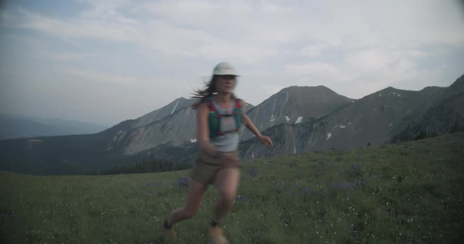The woman trips and falls while running on the field