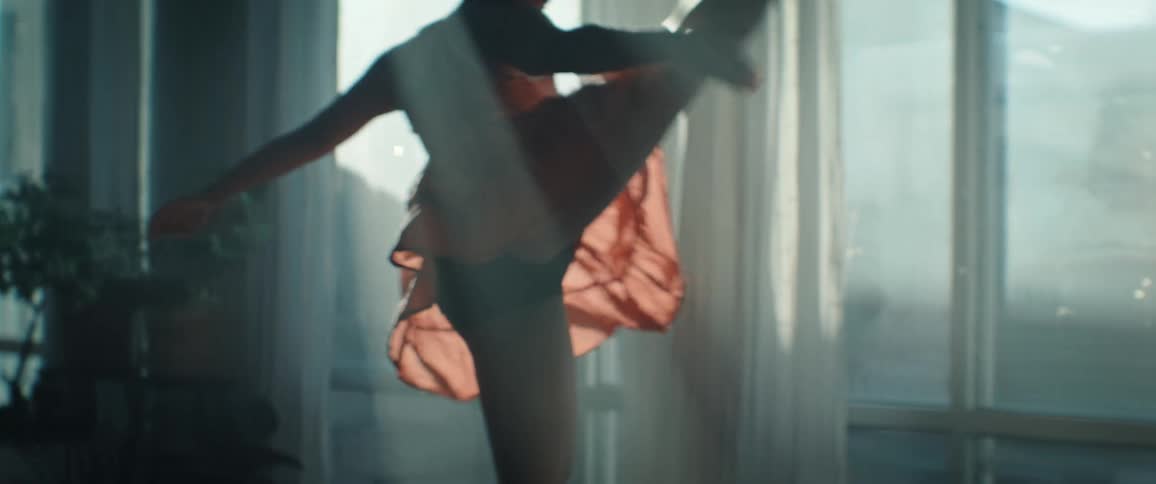 The woman kicks as she spins while dancing